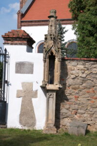 Śmiałowice. Krzyż i kapliczka pokutna przed bramą do kościoła.