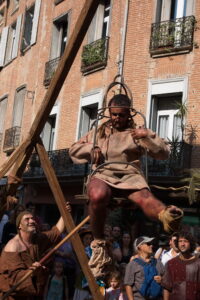 Perpignan (Francja). Skazaniec w klatce hańby podczas średniowiecznego jarmarku.