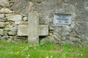 Nowolesie. Krzyż pokutny przed murem otaczającym kościół.